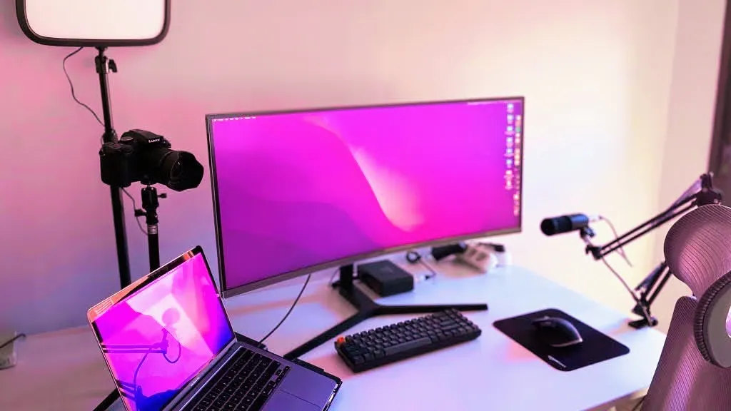 El setup de trabajo como developer de @baumannzone. Escritorio elevable + macbook pro + teclado mecánico + ratón ergonómico + monitor + micrófono + cámara web